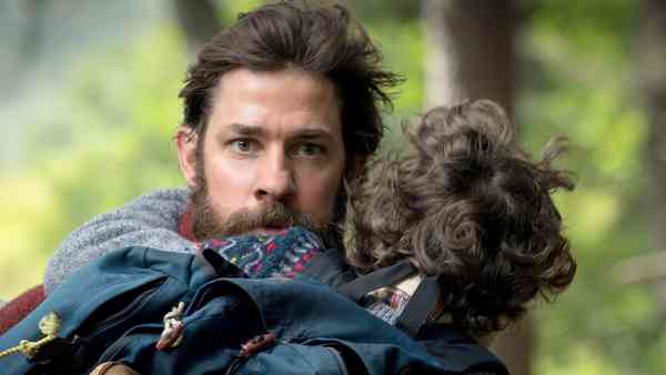 A Quiet Place Part III scene featuring John Krasinski carrying a child